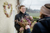 Landesrat Stefan Kaineder übernimmt einen Blumenstraß aus getrockneten Blumen 