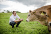 Landesrat Stefan Kaineder auf einer Weide mit einer Kuh