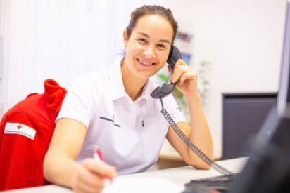 Mitarbeiterin des Roten Kreuzes beim Telefonieren