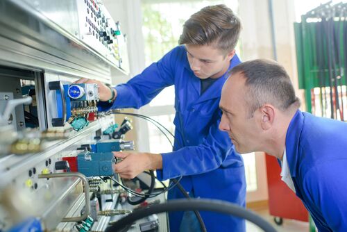 Zwei Männer arbeiten an einem Schaltgehäuse   