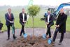 Landesrat Markus Achleitner, Martin Öller, Thomas Moser und Rüdiger Keinberger mit Spaten. Vor ihnen eine Erdgrube mit einem jungen Baum