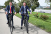 Landesrat Markus Achleitner und Landesrat Jochen Danninger nebeneinander auf E-Bikes auf einem Weg im Linzer Donaupark