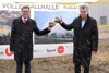 Landesrat Markus Achleitner und Sportminister Vizekanzler Mag. Werner Kogler, jeder mit einem Volleyball, vor einer Plakatwand mit Aufschrift: Volleyballhalle Ried im Innkreis