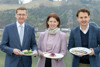 v.l.: LR Markus Achleitner, LRin Michaela Langer-Weninger und Mag. Andreas Winkelhofer stehen am Donauufer in Linz nebeneinander und halten jeweils ein Teller mit Essen in den Händen.