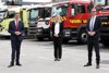 Landesrat Markus Achleitner, Dr.in Sabine Naderer-Jelinek und Ing. Mag. Daniel Tomaschko stehen vor vier unterschiedlichen Feuerwehr-LKW