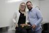 Kathrin und Christoph Rott stehen in einer Küchenecke und halten eine Platte mit dekoriertem Fisch in den Händen.