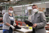 Hartjes-Mitarbeiterin und Landesrat Markus Achleitner, beide mit FFP2-Maske, in einer Produktionshalle an einem Werktisch, beide halten jeweils einen Schuh in Händen