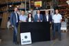 : Nationalrat Klaus Lindinger, Geschäftsführer Manfred Huemer, Clivia Huemer, Wirtschafts-Landesrat Markus Achleitner, Bürgermeister Günther See, Eberstalzell, Standortleiter Wilhelm Lehner, Huemer Energietechnik stehen nebeneinander in einem Lagerraum der Fa. Huemer Energietechnik, Eberstalzell, und halten eine große Energieplatte.