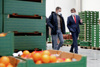 Alessandro Wolf und Wirtschafts-Landesrat Markus Achleitner in einer Lagerhalle, im Vordergrund Obstkiste