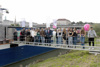 LR Markus Achleitner und DI Dr. Wilfried Enzenhofer, MBA, steht mit Schülerinnen und Schülern auf einer Zugangsbrücke zu einem Schiff auf der Linzer Donau, dahinter die Linzer Nibelungebrücke.