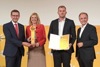 Landesrat Markus Achleitner und Mag.a Ursula Schmierer halten gemeinsam den Preis, Mag. Karl Niederndorfer mit Urkunde und Dr. Gerhard Dell stehen nebeneinander, dahinter auf einer Wand Logos des Energiesparverbandes, Solar Champion 2021 und Tips