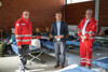 Landesrat Dr. Wolfgang Hattmannsdorfer steht zwischen zwei Mitarbeitern des Roten Kreuzes in einer Notschlafstelle in Linz.