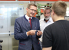 Landesrat Markus Achleitner im Gespräch mit zwei Mitarbeitern in einer Werkhalle