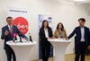 v.l.: LR Markus Achleitner, Petra Riffert, Herta Wiedlroither, und Mag. Andreas Winkelhofer stehen bei einer Pressekonferenz vor Stehtischen mit Mikrofonen und Trinkgläsern, dahinter zwei Roll-ups – oberoesterreich.at und carvan.