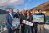 v.l.: Wirtschafts- und Tourismus-Landesrat Markus Achleitner, LH-Stv. Mag. Stefan Schnöll, Salzburg, Prof. Dr. Christian Meyer, kaufmännischer Geschäftsführer Wolfgang Betriebs-GmbH, Gerd Hermann Ortler, Komponist, Prof. Eduard Neversal, Architekt und künstlerischer Geschäftsführer, Franzobel, Schriftsteller stehen an Bord eines Schiffes am Wolfgangsee und halten drei Plakate in den Händen.