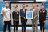 Simon Bucher, Susanne Walli, Landesrat Markus Achleitner und Dr. Peter Mennel mit Urkunde, und Verena Mayr stehen nebeneinander, Rückwand mit Beschriftung Sport Oberösterreich, Rollplakate mit Beschriftung Österreichisches Olympisches Comite, Austria Olympiazentrum