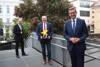 DI Dr. Gerhard Dell, Mag. Günther Hochrathner - hält einen Stern in der Hand -  und LR Markus Achleitner stehen vor der Papierfabrik Nettingsdorf dahinter ein Baum mit Blüten.