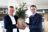 Wirtschafts-Landesrat Markus Achleitner (l.) überreichte TEAM 7-Geschäftsführer Dr. Georg Emprechtinger (r.) ein nachhaltiges Geschenk in Form eines kleinen Bäumchens.