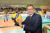 Landesrat Markus Achleitner mit Volleyball in Händen auf einer Tribüne in der Volleyball-Halle 
