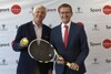 Ronnie Leitgeb und Landesrat Markus Achleitner stehen nebeneinander vor einer Plakatwand, Ronnie Leitgeb hält einen Tennisball, Markus Achleitner einen Tennisschläger.