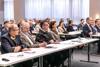 Großer Vortragsraum, zahlreiche Menschen an Tischen sitzend