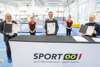 Helmut Kranzlmüller, Elisa Hämmerle, Landesrat Markus Achleitner, Lorena Böhmberger und Prof. Friedrich Manseder in einer Turnhalle vor einem Tisch mit Aufschrift Sport OÖ