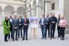 v.l.: Mag.a Brigitte Deu, Landesstellenleiterin Sozialministeriumservice OÖ, Andreas Stangl, Präsident Arbeiterkammer OÖ, Sozial-Landesrat Dr. Wolfgang Hattmannsdorfer, Stefan Guggenberger, Landessekretär ÖGB OÖ, Wirtschafts-Landesrat Markus Achleitner, Klima-Landesrat Stefan Kaineder, DI Dr. Joachim Haindl-Grutsch, Geschäftsführer Industriellenvereinigung OÖ, Gerhard Straßer, Landesgeschäftsführer Arbeitsmarktservice OÖ, Dr. Alfred Klampfer, Bildungsdirektor OÖ, Mag.a Doris Hummer, Präsidentin Wirtschaftskammer OÖ stehen nebeneinander im Freien in einem Innenhof, in ihrer Mitte ist ein Aufsteller mit einem Dokument des Paktes für Arbeit & Qualifizierung 2022, das von den Anwesenden unterfertigt wurde. 