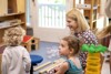 Landeshauptmann-Stellvertreterin Mag.a Christine Haberlander sitzt mit zwei kleinen Kindern in einem Spielzimmer