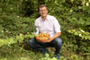 Landesrat Stefan Kaineder mit einem Körbchen voller Eierschwammerl in Händen in einem Wald