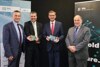 Wilfried Enzenhofer und Gerald Murauer mit Platine in Händen, Landesrat Markus Achleitner mit Platine in Händen und Ingolf Schädler stehen nebeneinander vor Rollplakaten der Silicon Austria Labs