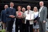 Franz Fleischanderl, Landesrat Markus Achleitner, Edeltraud Knoll mit Skulptur, Fritz Janko, Hubert Koller mit Urkunde, Anita Gstöttenmayr und Mag. Othmar Nagl stehen nebeneinander auf einer Bühne