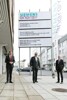 Landesrat Markus Achleitner, Josef Kinast und Arbeitsminister Martin Kocher vor dem Siemens-Gebäude, im Hintergrund große Firmentafel mit Aufschrift Siemens Energy