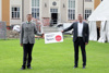 Landesrat Markus Achleitner und Armin Grünbart auf einem Rasen, gemeinsam halten sie eine Tafel mit Beschriftung Infrastruktur-Offensive Sport Oberösterreich