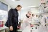 Landesrat Stefan Kaineder steht in einem Labor mit einer Frau und bekam Einblicke in die Laborarbeit der AGES in Linz.