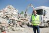 Landesrat Stefan Kaineder vor einem riesigen Müllhaufen in einer Deponie