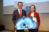 Landesrat Achleitner und Ministerin Leonore Gewessler halten ein kleines Plakat mit Aufschrift Für die Energiewende Adieu Öl