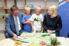 LH-Stv.in Haberlander und LR Achleitner mit Kindern beim Buch anschauen. 