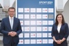 Wirtschafts- und Sport-Landesrat Markus Achleitner und Lisa Hirtenlehner, Oberösterreichs erste Teilnehmerin des neuen Gender-Trainee-Programms, vor einer Tafel des Sportlandes OÖ.