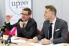 Landesrat Markus Achleitner und Werner Pamminger an einem Konferenztisch mit Mikrofonen, im Hintergrund ein Plakat mit Aufschrift upper austria