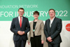 Landesrat Markus Achleitner, Henriette Spyra und DI Dr. Wolfgang Hribernik stehen nebeneinander vor einer Wand mit Beschriftung Innovation Network for Industry 2022