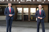 Landesrat Markus Achleitner und Dr. Alexander Susanek vor dem Eingang eines Bürogebäudes