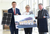 Landesrat Markus Achleitner mit Solarpanel, Ing.in Mag.a Petra Weiss und Bischof Dr. Manfred Scheuer mit Solarpanel stehen nebeneinander am Gang des OÖ. Presseclubs, gemeinsam halten sie ein Bild eines schönen alten Gebäudes in Händen.