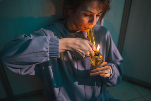 Eine Frau raucht Haschisch mit einer Wasserpfeife.