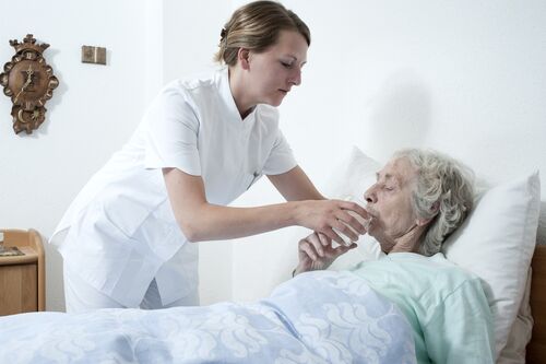 Altenpflegerin am Bett einer Patientin