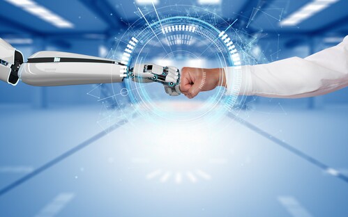 Menschenarm und Roboterarm berühren sich mit ihren Fäusten
