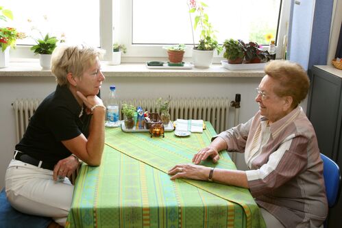 Ältere Frau mit Betreuerin in ihrer Wohnung