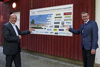 Dr. Wolfgang Artmann und Landesrat Markus Achleitner zeigen auf eine Tafel mit der Aufschrift Der Brückenschlag zum Erweiterungsbau ist geschafft!