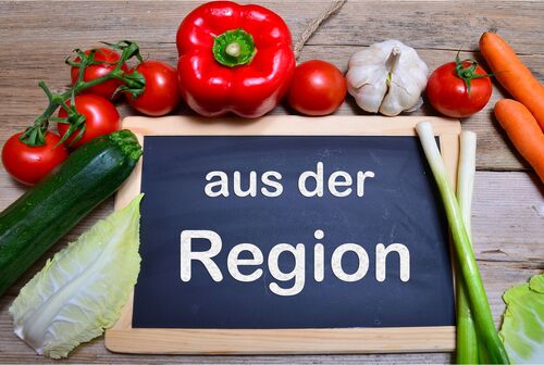 Jausenbrett mit Gemüse, auf einer Tafel steht aus der Region