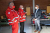 Landesrat Wolfgang Hattmannsdorfer im Gespräch mit zwei Mitarbeitern des Roten Kreuzes in Linz, im Hintergrund Betten in einer Notschlafstelle.