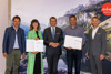 v.l.: Andreas Winkelhofer (Geschäftsführer Oberösterreich Tourismus), Katharina Weglehner (Boutique Hotel Sissikuss Bad Ischl), Wirtschafts- und Tourismus-Landesrat Markus Achleitner, Alois Harringer (Taxi-Spot Gosau) und Werner Pamminger (Geschäftsführer Business Upper Austria) stehen vor einer Plakatwand des OÖ Tourismus nebeneinander, Weglehner und Harringer halten eine geöffnete Diplom-Mappe in Händen.